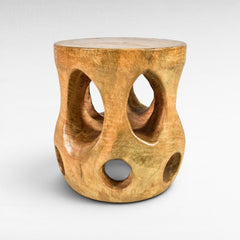 Chora Barefoot Luxury Living carved wood side table with curved openwork design and circular cutouts.