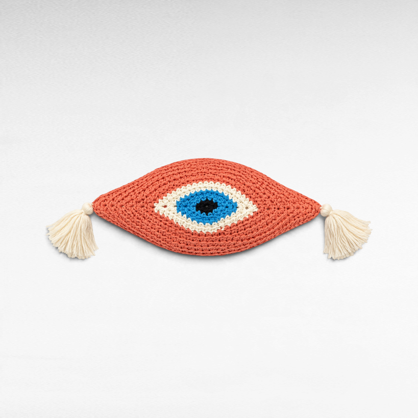 Chora Barefoot Luxury Living cotton eye pillow in coral, blue, white, and black with decorative side tassels.