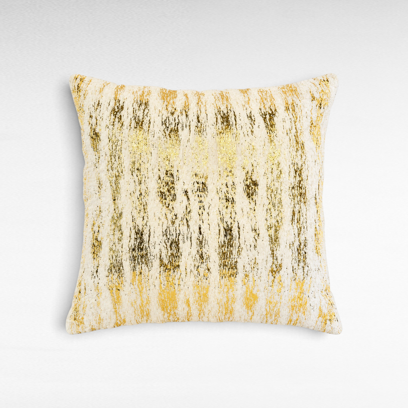 Chora Barefoot Luxury Living square decorative pillow featuring a textured white fabric with gold brushstroke patterns.