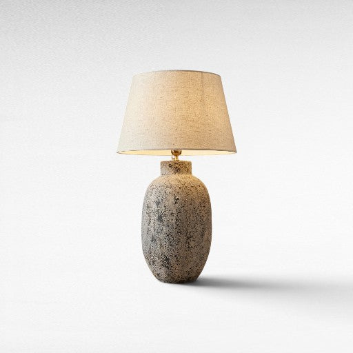 Chora Barefoot Luxury Living grey terracotta table lamp with textured finish and linen shade, providing ambient lighting.