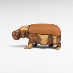 Chora Barefoot Luxury Living hippo-shaped stool crafted from natural wood with a smooth tan leather seat.