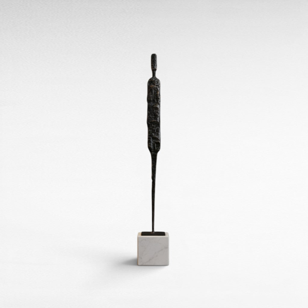 Chora Barefoot Luxury Living abstract black iron figurine on white marble base, modern sculpture.