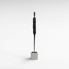Chora Barefoot Luxury Living abstract black iron figurine on white marble base, modern sculpture.