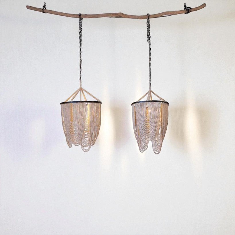 Chora Barefoot Luxury Living Ivory Cascade beaded chandelier with loops of bleached wood beads on a metal frame.