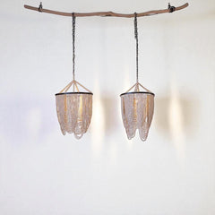 Chora Barefoot Luxury Living Ivory Cascade beaded chandelier with loops of bleached wood beads on a metal frame.