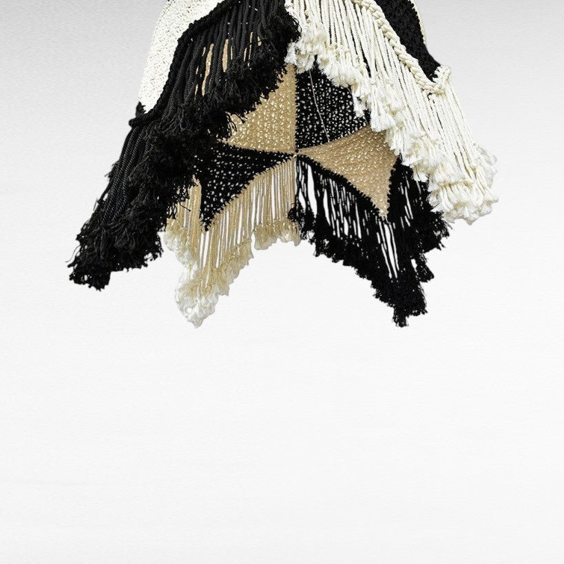 Chora Barefoot Luxury Living handmade macrame hanging decor in black, white, and natural tones with fringe details.