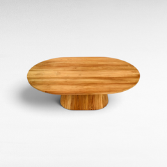 Chora Barefoot Luxury Living oval suar wood dining table with natural honey grain patterns and pedestal base