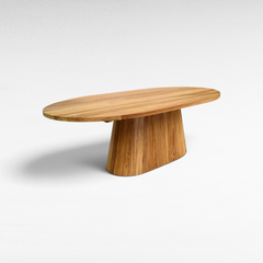 Chora Barefoot Luxury Living oval suar wood dining table with organic grain patterns and a solid pedestal base.