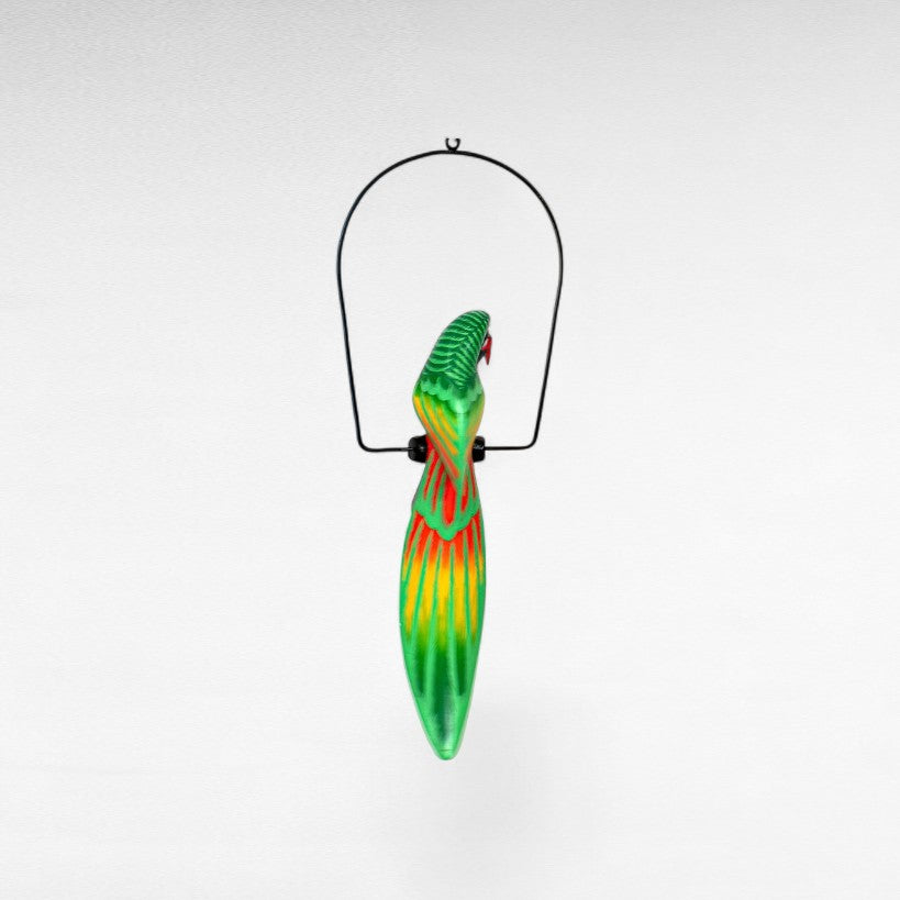 Chora Barefoot Luxury Living green, yellow, and red painted parrot decoration hanging from a metal stand.