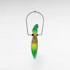 Chora Barefoot Luxury Living green, yellow, and red painted parrot decoration hanging from a metal stand.