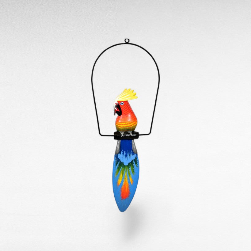 Chora Barefoot Luxury Living colorful wooden parrot decoration with a black metal hanger and a long blue tail with painted feathers.