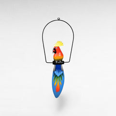 Chora Barefoot Luxury Living colorful wooden parrot decoration with a black metal hanger and a long blue tail with painted feathers.