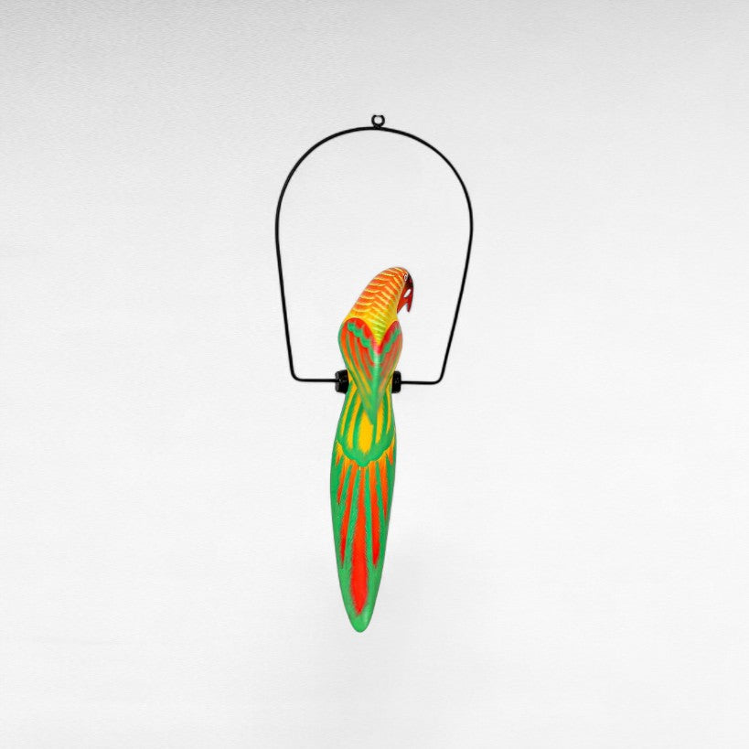Chora Barefoot Luxury Living colorful parrot decoration, painted wood, hanging from black metal stand.