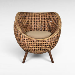 Chora Barefoot Luxury Living round rattan armchair with beige cushion and tapered wooden legs