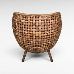 Chora Barefoot Luxury Living woven rattan chair with curved back and wooden legs, natural brown.