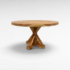 Chora Barefoot Luxury Living round wooden dining table with a sturdy cross-base design in a natural oak finish.