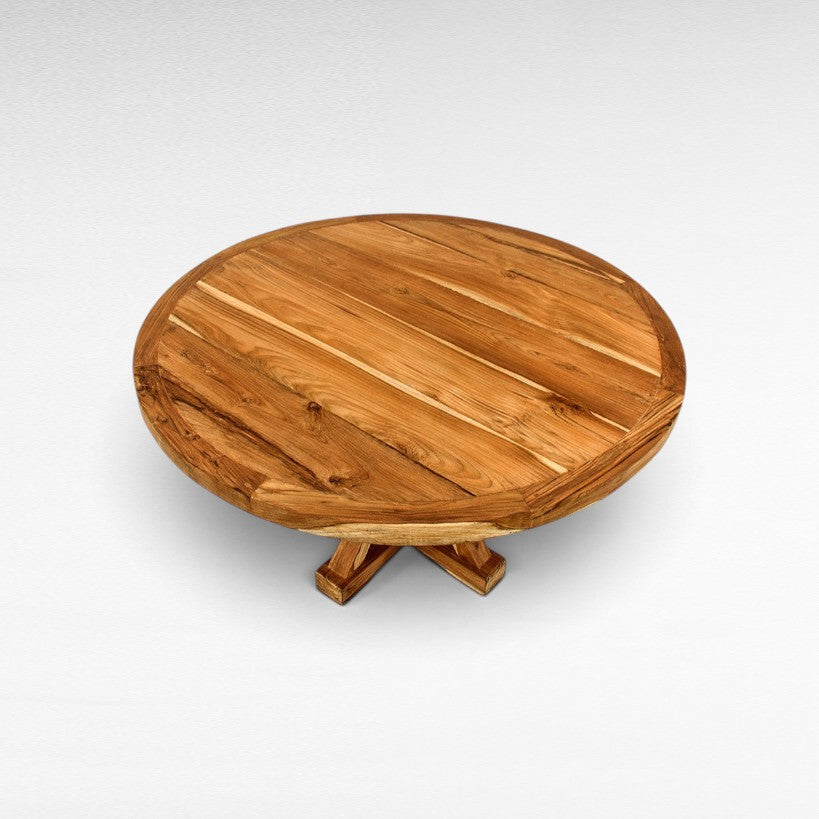 Chora Barefoot Luxury Living round wooden dining table with a natural grain finish and sturdy cross-base design.