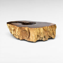 Chora Barefoot Luxury Living natural suar wood coffee table with hollow center and rough bark base. Warm brown tones.