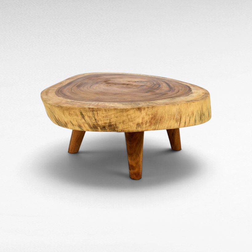 Chora Barefoot Luxury Living round suar wood coffee table with natural slab top and three angled wooden legs.