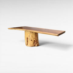 Chora Barefoot Luxury Living handcrafted suar wood dining table with natural grain patterns and a unique tree trunk base. Seats up to 10.