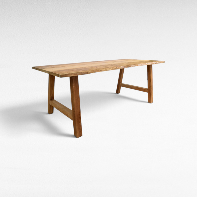 Chora Barefoot Luxury Living handcrafted suar wood dining table with natural live edge and sturdy trestle base.