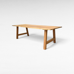 Chora Barefoot Luxury Living handcrafted suar wood dining table with natural live edges and sturdy trestle base.