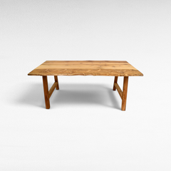 Chora Barefoot Luxury Living handcrafted suar wood dining table with a natural live edge and rich grain patterns.