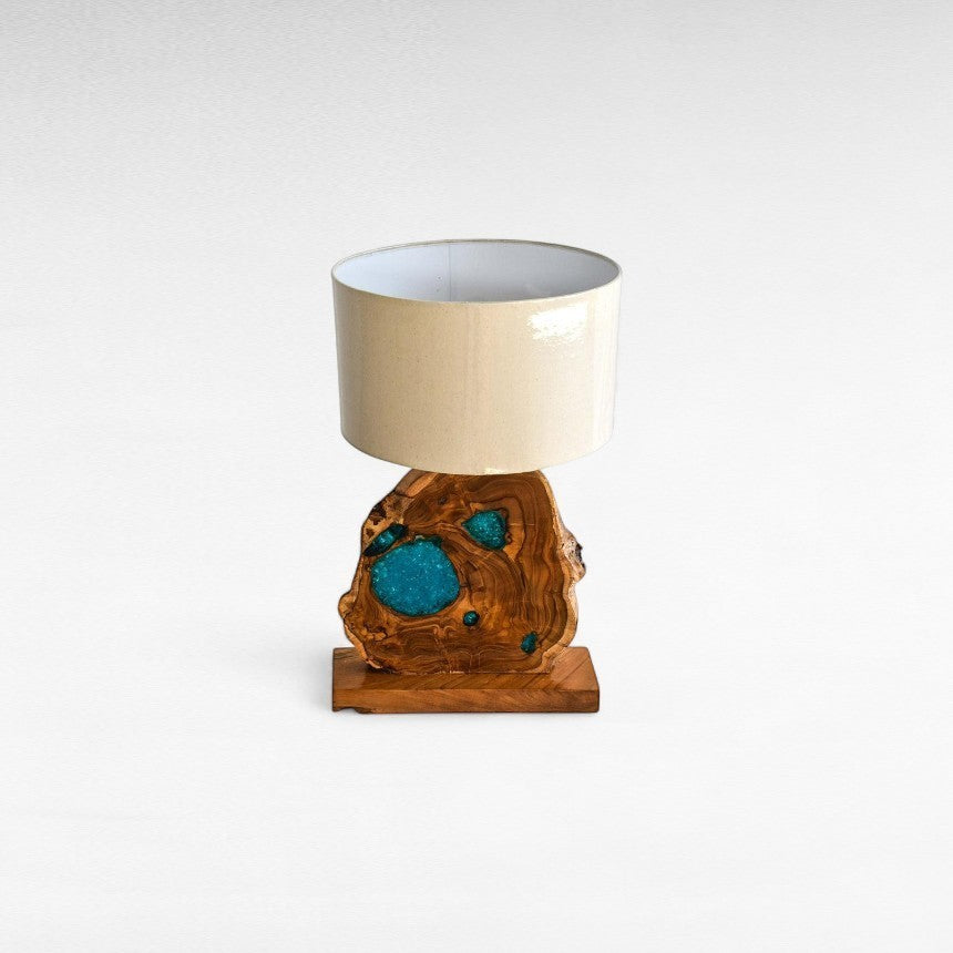 Chora Barefoot Luxury Living teak wood and blue resin table lamp with beige drum shade.