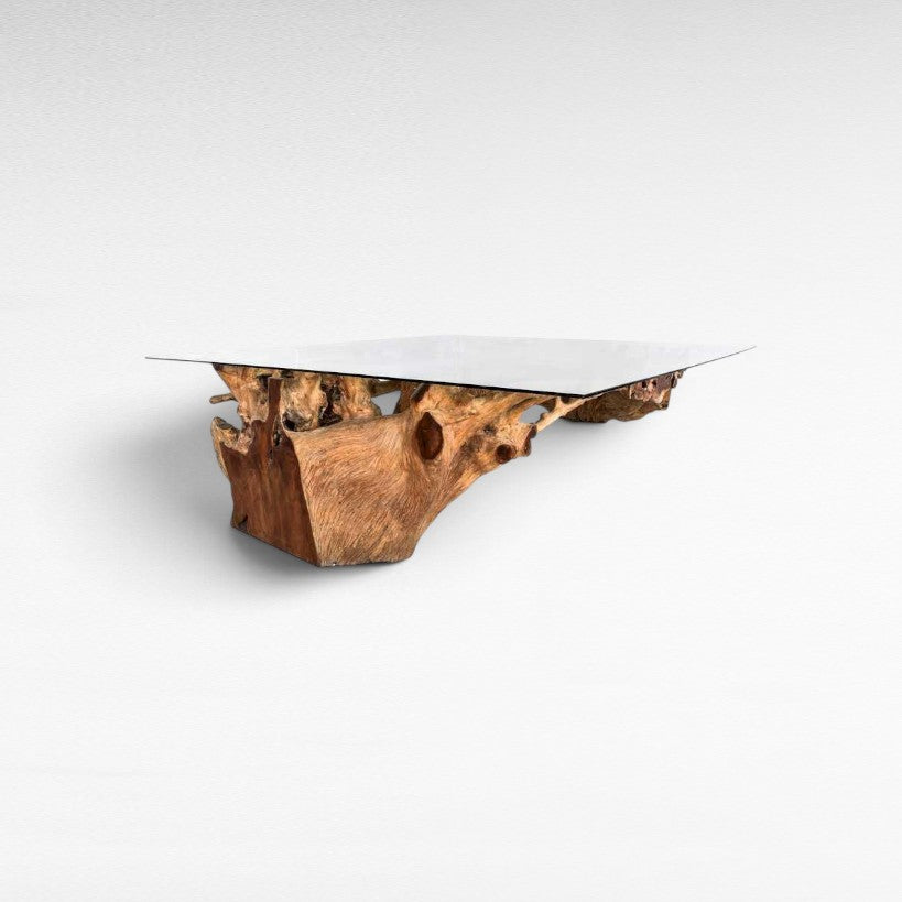 Chora Barefoot Luxury Living dining table with a natural teak wood root base and a clear rectangular glass top