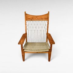Chora Barefoot Luxury Living teak wood armchair with a woven synthetic raffia seat and decorative knotted backrest.