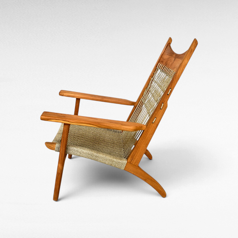 Chora Barefoot Luxury Living teak wood armchair with a woven synthetic raffia seat and decorative knotted back.