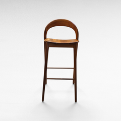 Chora Barefoot Luxury Living teak wood bar stool with a curved backrest and minimalist design on a white background.