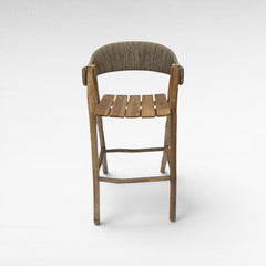 Chora Barefoot Luxury Living teak wood bar stool with woven synthetic raffia seat and back. Natural wood finish.