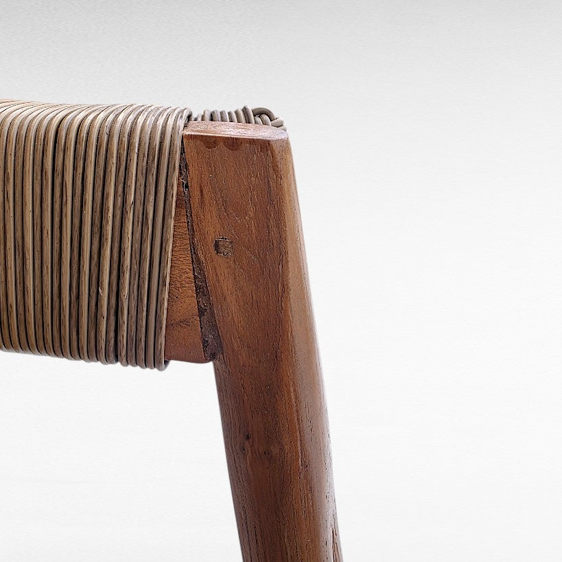 Chora Barefoot Luxury Living teak wood bar stool with synthetic raffia weaving. Natural wood frame with woven seat detail.