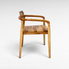 Chora Barefoot Luxury Living handcrafted teak wood dining chair with natural grain and warm honey tones, side view.