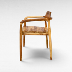 Chora Barefoot Luxury Living handcrafted teak wood chair with natural grain and warm honey tones, side view.