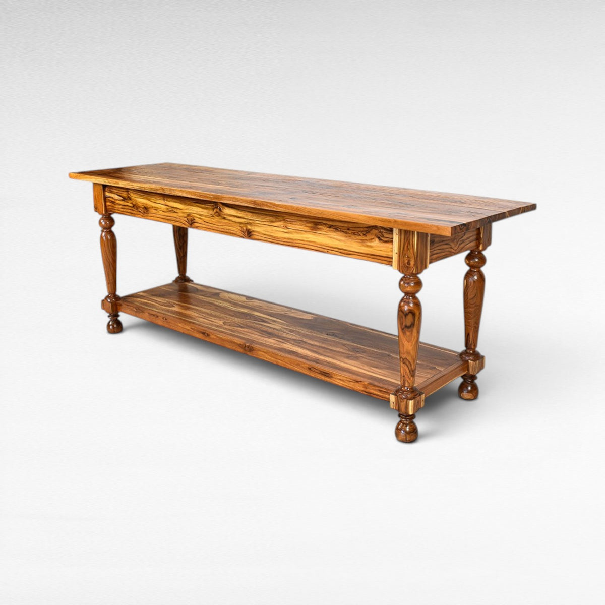 Chora Barefoot Luxury Living console table made of teak wood with turned legs and a lower shelf. Natural wood grain.