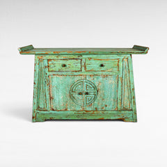 Chora Barefoot Luxury Living distressed teal buffet with two drawers and carved circular motif on doors.