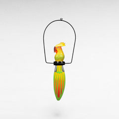 Chora Barefoot Luxury Living colorful wooden parrot decoration with yellow, green, and orange stripes, hanging from a black metal hoop.