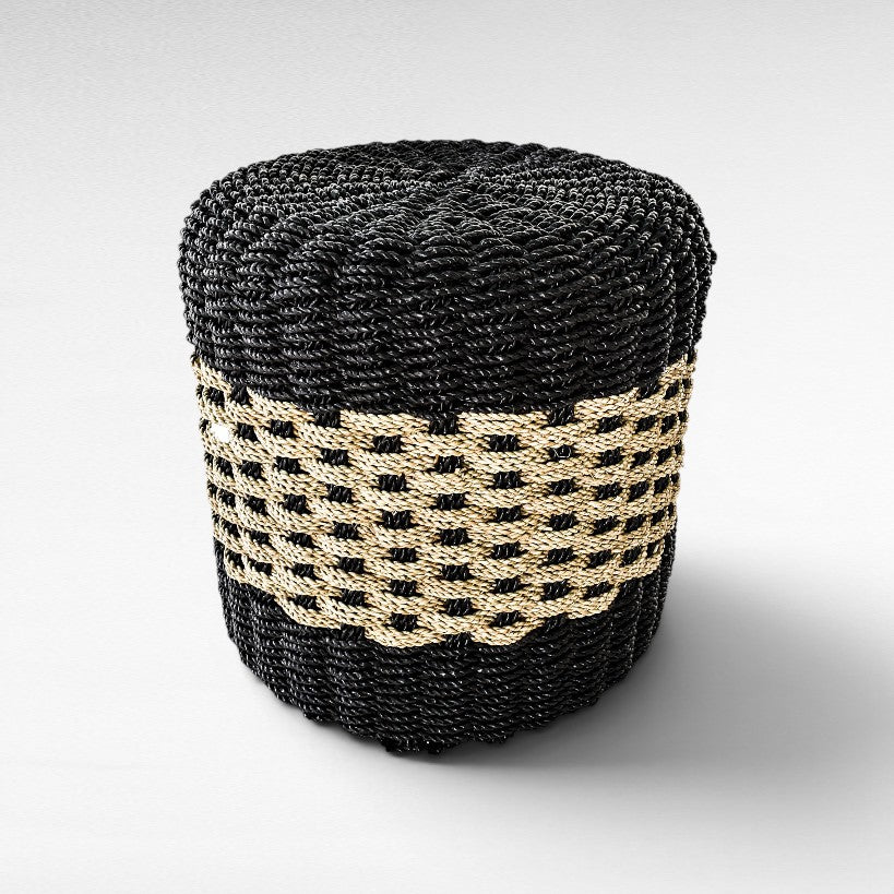 Chora Barefoot Luxury Living round stool featuring a black and natural woven grass pattern on a sturdy wood frame.