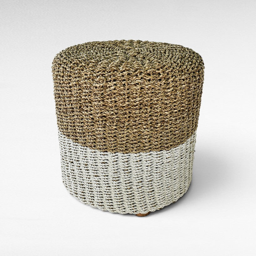 Chora Barefoot Luxury Living round stool featuring a natural woven grass top and a white painted woven base.