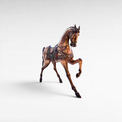 Chora Barefoot Luxury Living natural and black suar wood horse statue with ornate saddle and bridle, detailed wood grain.