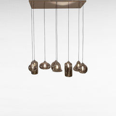 Chora Barefoot Luxury Living reflective black metal and glass pendant light with multiple glass shades.