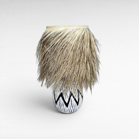 Chora Barefoot Luxury Living black and white patterned wood table lamp with natural raffia fringe shade.