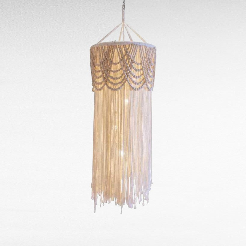 Chora Barefoot Luxury Living cream macrame pendant light with wooden beads and tassels, cylinder shape.