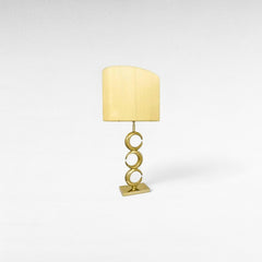 Chora Barefoot Luxury Living gold metal table lamp with a cream textured shade and stacked circular base.