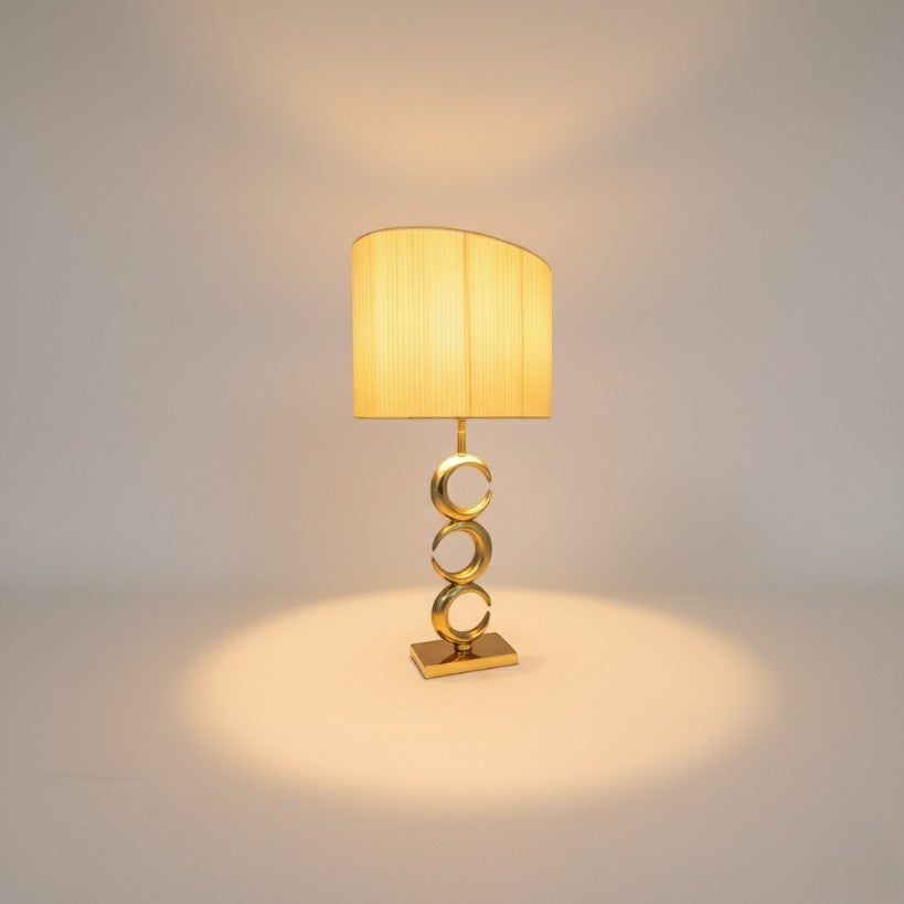 Chora Barefoot Luxury Living gold metal table lamp with a pleated cream shade and a stacked ring design on the base.