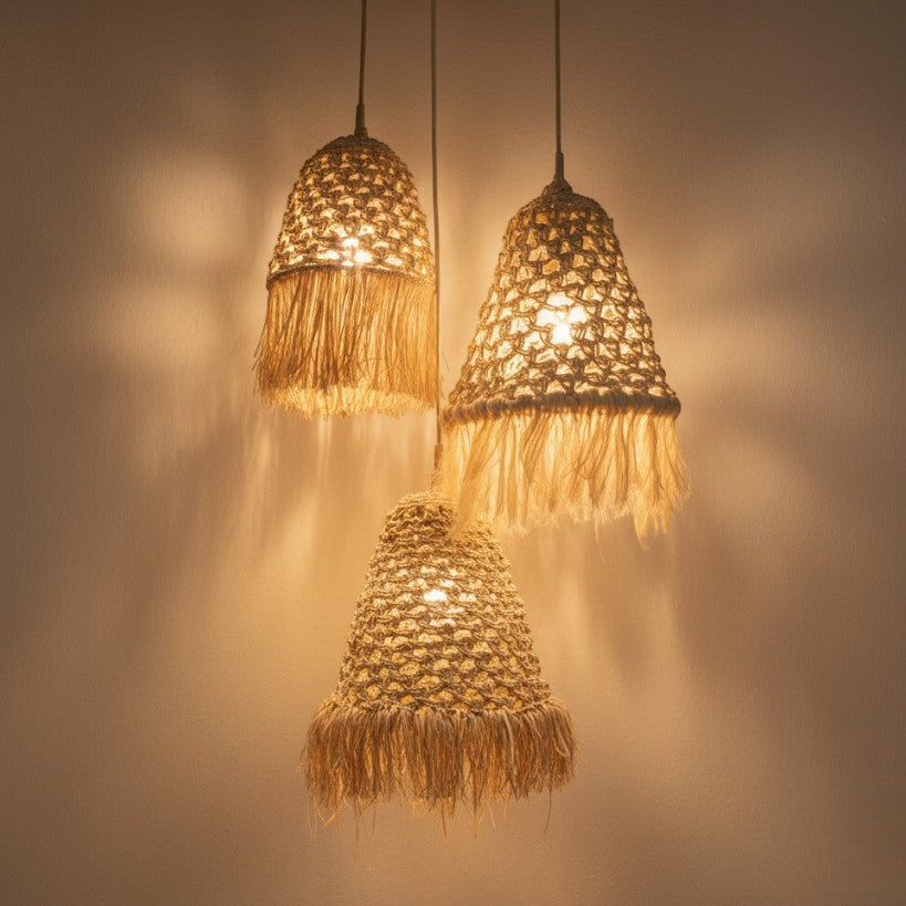 Chora Barefoot Luxury Living natural rattan and rice pendant light with fringe detail, casting warm light.