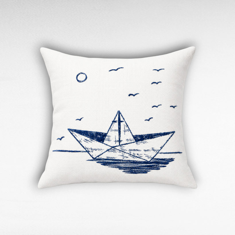 Chora Barefoot Luxury Living Dreamboat square throw pillow with blue embroidered paper boat design on white fabric